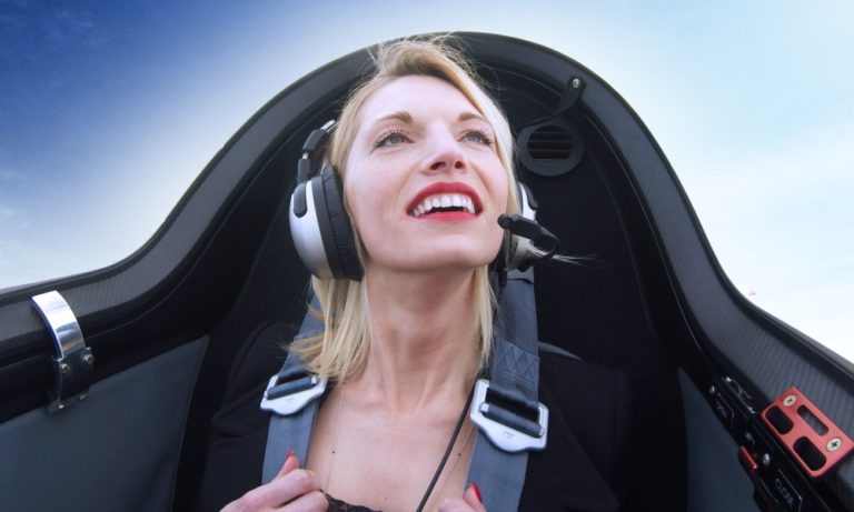 Tolle Aussichten - Frau schaut aus dem Flugzeugcockpit